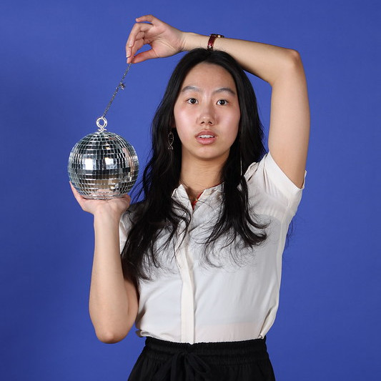 Jeune femme tenant une boule disco